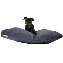 Load image into Gallery viewer, Black Labrador on a grey large dog bed on a white background.
